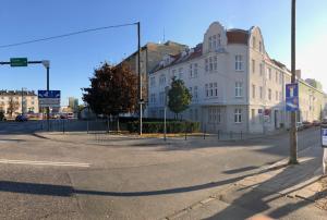 eine leere Straße mit einem großen weißen Gebäude in der Unterkunft Lillu Apartament 2 in Bydgoszcz