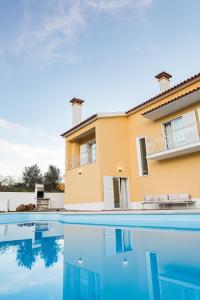 une villa avec une piscine en face d'une maison dans l'établissement Casa Souto da Serra, à Portalegre