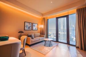 a living room with a couch and a large window at THE CLOSEST building to Burj Khalifa with Fountain View in Address Opera Residence in Dubai +24 photos