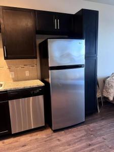 una cocina con nevera de acero inoxidable y armarios negros en Comfortable Apartment in Dallas, en Addison
