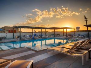 a swimming pool with lounge chairs and the sunset at Comfortable Apartment in Dallas in Addison