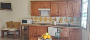 a kitchen with wooden cabinets and a table with fruit at Estrella de Sal in Villa de Mazo