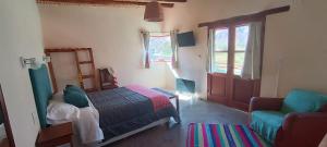1 dormitorio con 1 cama, 1 silla y 1 ventana en Balconcito de Colores en Maimará