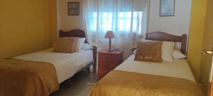 a bedroom with two beds and a lamp on a night stand at Estrella de Sal in Villa de Mazo