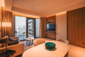 a living room with a table and a room with a view at THE CLOSEST building to Burj Khalifa with Fountain View in Address Opera Residence in Dubai