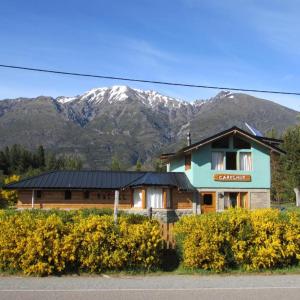 a large house with mountains in the background at Carelhue in Epuyén