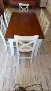a wooden table with four white chairs around it at Casa En Acantilados Mar del Plata in Mar del Plata