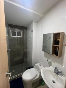 uma casa de banho com um chuveiro, um WC e um lavatório. em Cozy Apartment with pool em Montería