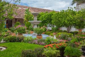 einen Garten mit einem Brunnen und Blumen in der Unterkunft Hotel Boutique Adela in Granada