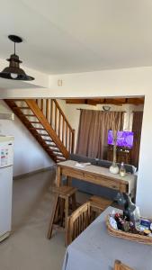 Una sala de estar con una mesa y una escalera. en Duna Zuriak 2, en Playas Doradas