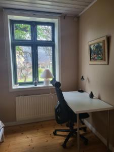 escritorio y silla en una habitación con ventana en Sahlin - Ängelholm, en Ängelholm