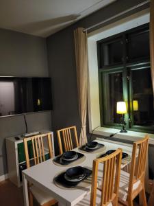 uma cozinha com uma mesa e cadeiras, uma mesa e uma janela em Sahlin - Ängelholm em Ängelholm