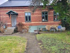 uma casa de tijolos com uma mesa e cadeiras em frente em Sahlin - Ängelholm em Ängelholm