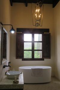 baño con bañera, lavabo y ventana en Hacienda Tovares, en Cadereyta de Montes