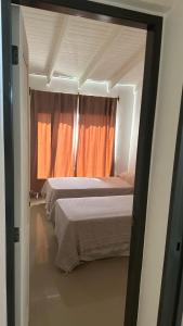 1 dormitorio con 2 camas y cortina de color naranja en Duna Zuriak 2 en Playas Doradas