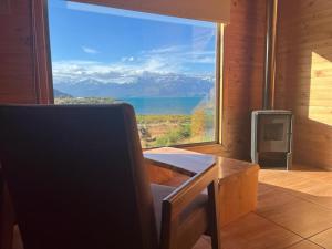 a room with a large window with a view of the water at El Arrayan in Puerto Guadal