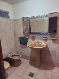 a bathroom with a sink and a toilet and a mirror at Casa La Chacra in Humahuaca