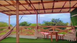 a screened in porch with swings and a hammock at Verano Azul Loft in Puerto López