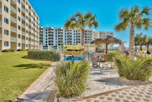 a resort with a playground with palm trees and a building at Islander 311 Sandy Dunes in Destin
