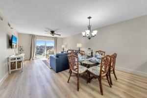 a dining room with a table and a blue couch at Islander 311 Sandy Dunes in Destin