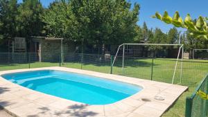 ein Pool in einem Garten mit einem Zaun in der Unterkunft La Damasca in Mendoza