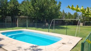a swimming pool in a yard with a fence at La Damasca in Mendoza