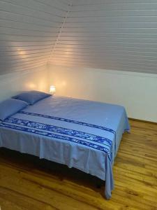 una camera da letto con un letto con lenzuola blu sopra di Fare Manu Ura, Maison Tropicale accueillante a Paea