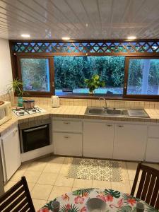 a kitchen with a sink and a counter top at Fare Manu Ura, Maison Tropicale accueillante in Paea