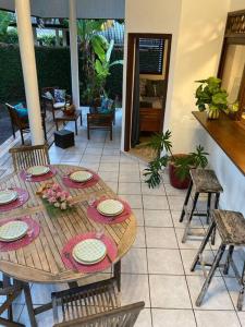 een houten tafel met borden op een patio bij Fare Manu Ura, Maison Tropicale accueillante in Paea