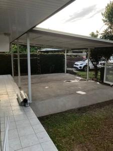 a covered parking lot with a suitcase sitting under it at Fare Manu Ura, Maison Tropicale accueillante in Paea