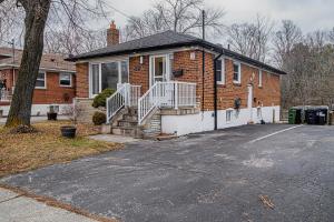 a brick house with a porch and a driveway at Charming Cozy Ravine Home Mins to Parks & Lake Entire House in Toronto