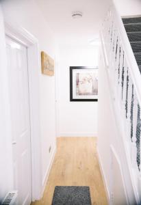 a hallway with white walls and stairs with a rug at 6 bedroom property in Sidcup