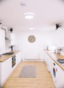 a kitchen with white cabinets and a wooden floor at 6 bedroom property in Sidcup