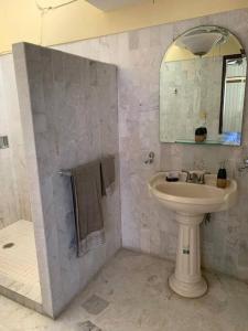 a bathroom with a sink and a mirror at La casa del cerro con vista al oceano pacifico in Mazatlán