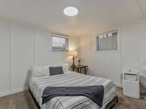 a white bedroom with a bed and two windows at Centrally Located in the Heart of Provo 2 BR in Provo