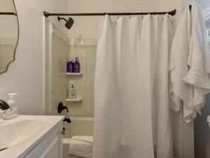 baño con cortina de ducha blanca y lavamanos en 4 BR Duplex Next to the Bees Stadium, en Salt Lake City
