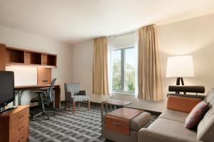 a living room with a couch and a desk at TownePlace Suites Boca Raton in Boca Raton