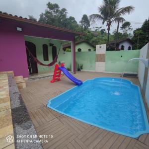 uma piscina com escorrega e um parque infantil em Casa Muro Alto-Sana Rj em Macaé