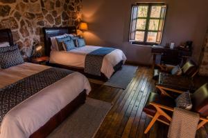 une chambre avec deux lits et un mur en pierre dans l'établissement Hacienda Tovares, à Cadereyta de Montes 84 autres photos