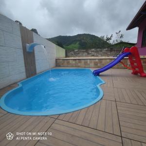 a swimming pool with a water fountain on a deck at Casa Muro Alto-Sana Rj in Macaé