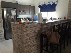 eine Küche mit einer Theke mit Stühlen und einem Kühlschrank in der Unterkunft MM VILLA in Panama-Stadt