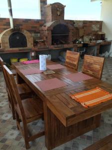 una mesa de madera con sillas y un horno de pizza en MM VILLA, en Panamá