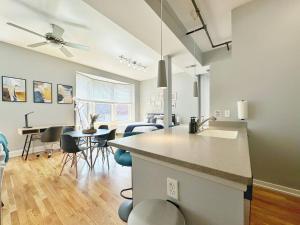 a kitchen and living room with a counter and chairs at Boho Studio Loft Meets Luxury in the Heart of Cincinnati! in Cincinnati