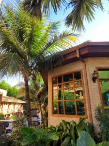 a house with palm trees in front of it at Hotel Pousada Santa Rita in Ribeirão Preto