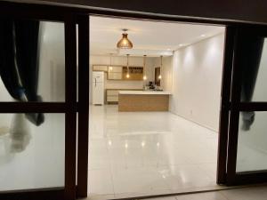 a view of a kitchen from a glass door at Casa de praia Enseadas do corais - 20 metros da praia in Cabo de Santo Agostinho