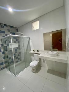 uma casa de banho com um WC, um lavatório e um chuveiro em Casa de praia Enseadas do corais - 20 metros da praia em Cabo de Santo Agostinho