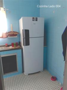 a kitchen with a white refrigerator in a room at Quarto Carnaval 2024 Salvador in Salvador