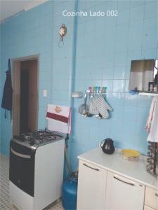 a kitchen with a stove and a blue tiled wall at Quarto Carnaval 2024 Salvador in Salvador