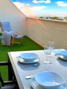 una mesa con platos y copas de vino en el balcón en Ático SALINAS de Mar, en Roquetas de Mar