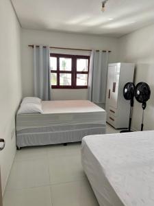 um quarto com 2 camas e um frigorífico em Casa de praia Enseadas do corais - 20 metros da praia em Cabo de Santo Agostinho